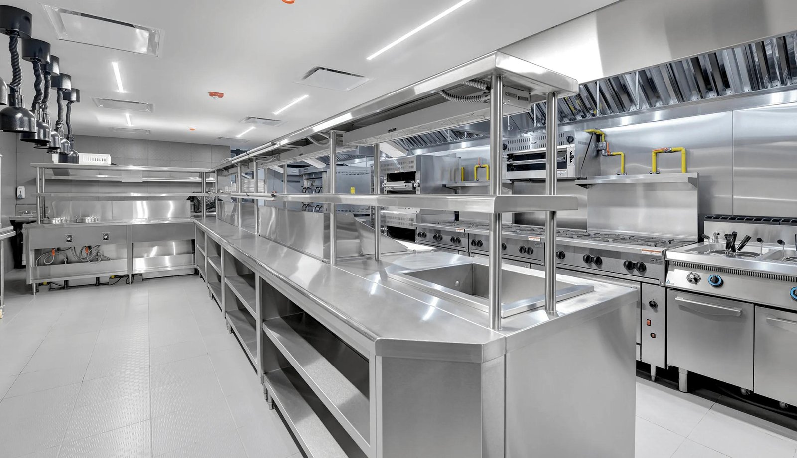 Large commercial kitchen with stainless steel counters and equipment — illustrative image